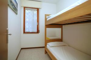 a bedroom with two bunk beds and a window at Villa Capinera in Lignano Sabbiadoro