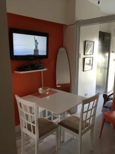 una sala da pranzo con tavolo e sedie bianchi e una TV di Apartment at Tagaytay Prime Residences a Tagaytay