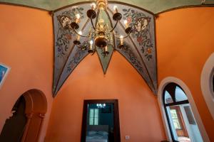 a chandelier in a room with orange walls at The Englishman's Clock Tower Hostel & More in Shkodër