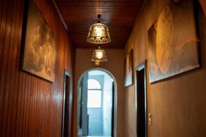 a hallway with a chandelier and an arched doorway at The Englishman's Clock Tower Hostel & More in Shkodër