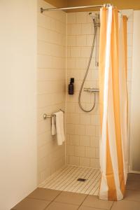 a shower with an orange shower curtain in a bathroom at Hôtel Les Voisins Beaucemaine in Ploufragan +114 photos
