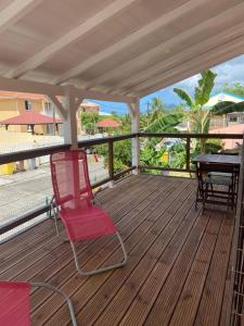 una sedia rossa seduta su un ponte con tavolo di Kay Margo a Sainte-Luce