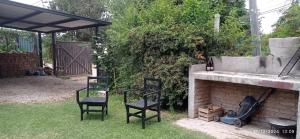 two chairs and a fireplace in a yard at Entrepinos I in Juana Koslay 