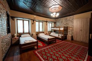 a bedroom with two beds and a red rug at Kulla Inglizit in Shkodër