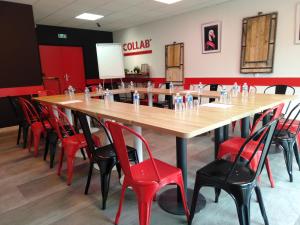a large table with red chairs in a restaurant at Urban Style Arl HOTEL in Arles