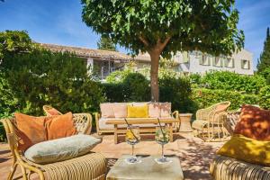 a patio with chairs and a table with wine glasses at La Ferme D'Augustin in Saint-Tropez