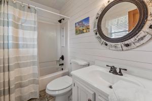 a bathroom with a sink and a toilet and a mirror at Rose Cottage in Rodanthe +14 photos