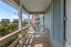 a porch with a rocking chair on a house at Rose Cottage in Rodanthe