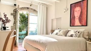 a bedroom with a bed and a painting on the wall at Borgo dei Sogni - Deluxe Apartment with Terrace - Lago di Garda in San Felice del Benaco
