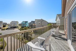 a deck with two white chairs on a house at DR13- Salty Dog in Nags Head