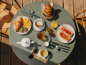 a round table with breakfast foods on it at Hôtel le Bout du Parc de Versailles in Versailles