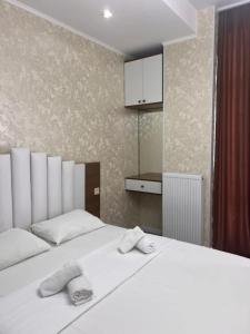a bedroom with a white bed with two towels on it at Comfort class apartment 10 in Kutaisi
