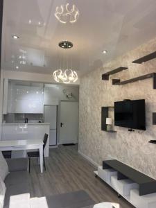 a living room with a table and a tv on a wall at Comfort class apartment 10 in Kutaisi