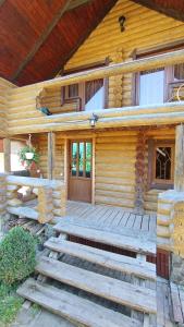 a log cabin with a porch and a wooden door at Затишний будиночок in Bukovets
