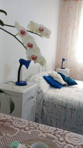 a bedroom with a bed and a vase with flowers at La Casa di Tina in Ischia +17 photos