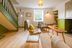 a living room with green walls and a table and chairs at 4 Low Rake - Former Miners Cottage in Glenridding