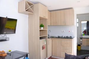 a kitchen with wooden cabinets and a refrigerator at Wild Wood Cottages, Naivasha in Naivasha