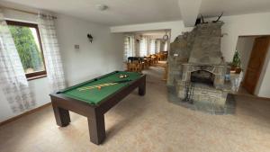 a living room with a pool table and a fireplace at Willa Agma in Zakopane