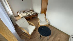 a room with two chairs and a table and a bed at Willa Agma in Zakopane