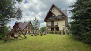 a large house with a playground in the yard at Willa Agma in Zakopane