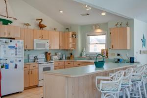 a kitchen with wooden cabinets and a white refrigerator at Sea Dreamer in Nags Head