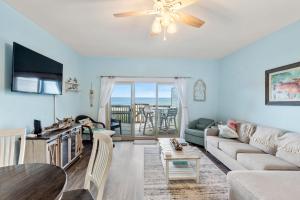 Una sala de estar con un sofá y un ventilador de techo. en Seawalk Condos, en Kill Devil Hills