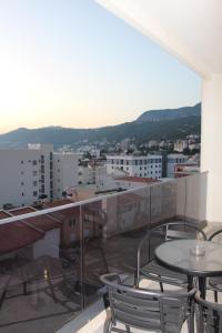 a balcony with tables and chairs on a building at AMD - stan 314 in Dobra Voda
