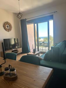 a living room with a couch and a table and a television at Nicks sea view appartement II in Petrovac na Moru