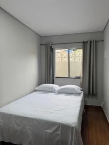 a white bed in a room with a window at Hotel e Restaurante Casa Velha in Barra Longa