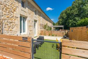 ein Gebäude mit einem Tor und einem Zaun in der Unterkunft Napoléon in Saint-Genis-de-Saintonge