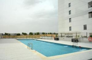 a swimming pool in front of a building at Timeless Elegance in Rivas in Rivas-Vaciamadrid
