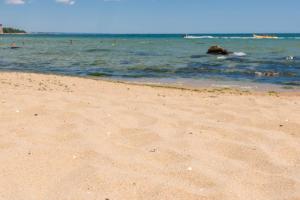 a sandy beach with people swimming in the water at Luxury Ap Blanka - Pool & Panorama in Azur in St. St. Constantine and Helena