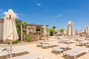 a bunch of chairs and umbrellas with a sign at Luxury Ap Blanka - Pool & Panorama in Azur in St. St. Constantine and Helena
