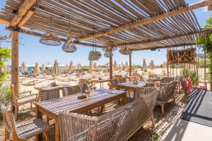 an outdoor restaurant with tables and chairs and umbrellas at Luxury Ap Blanka - Pool & Panorama in Azur in St. St. Constantine and Helena