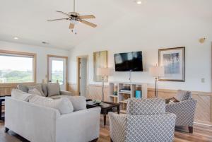 a living room with a couch and chairs and a tv at Seaside 46 in Nags Head +35 photos