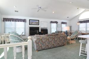 ein Wohnzimmer mit Sofa, Tisch und Stühlen in der Unterkunft Seaside 58 by Village Realty in Nags Head