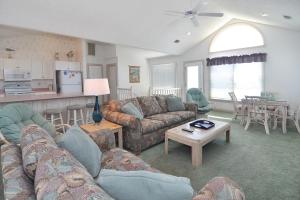 ein Wohnzimmer mit Sofas und einem Tisch sowie eine Küche in der Unterkunft Seaside 58 by Village Realty in Nags Head + 25 Fotos