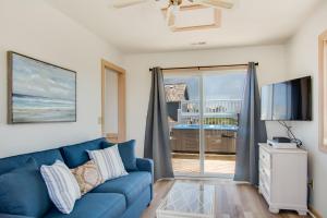 a living room with a blue couch and a tv at Seaside 46 in Nags Head