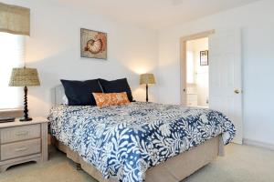 ein Schlafzimmer mit einem Bett mit einer blau-weißen Bettdecke in der Unterkunft Seaside 58 by Village Realty in Nags Head