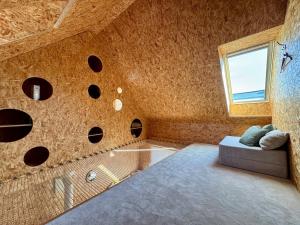 a room with a bed and a window and a couch at Maison atypique, au coeur de Sainte Marine in Combrit