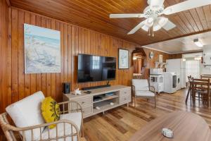 a living room with a television on a wooden wall at Seasons in the Sun in Nags Head