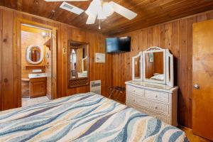 a bedroom with a bed and a dresser and a mirror at Seasons in the Sun in Nags Head