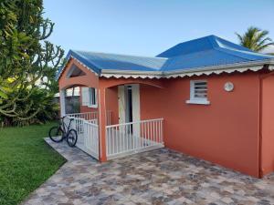 a small red house with a bike on the porch at Villa Bellevue in Sainte-Rose