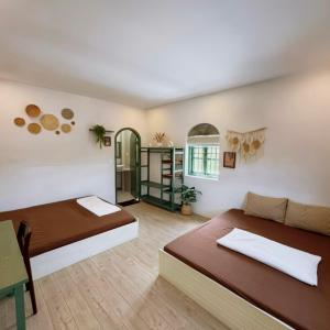 ムイネーにあるA House - homestay Mui Neのベッド2台とテーブルとソファのある部屋