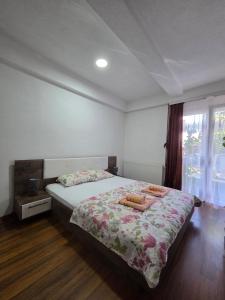 um quarto com uma cama com uma colcha floral em Anastasija Apartments em Ohrid