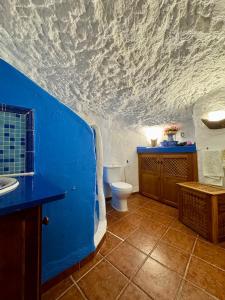 a blue bathroom with a toilet and a sink at Cueva Solaz Galera in Galera +15 photos