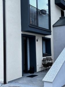 a building with a balcony and a table and chairs at Mountain spot in a cozy nest in Airolo