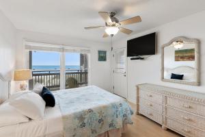 1 dormitorio con 1 cama con ventilador de techo y TV en Shyers Luck, en Kill Devil Hills