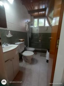 ein Badezimmer mit Toilette, Waschbecken und Dusche in der Unterkunft Cabañas Las Brisas in Puerto Madryn
