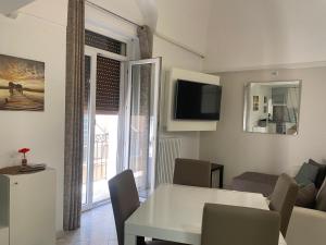 sala de estar con mesa blanca y TV en casa sui sassi A, en Matera